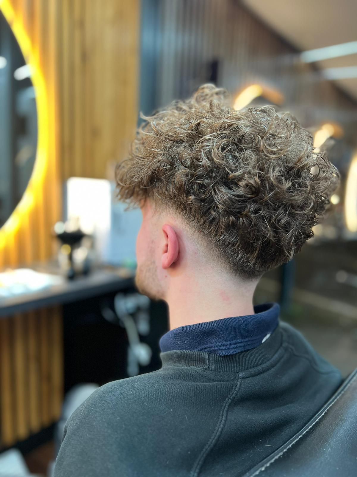 Finished curly haircut with a clean taper at Hadi's