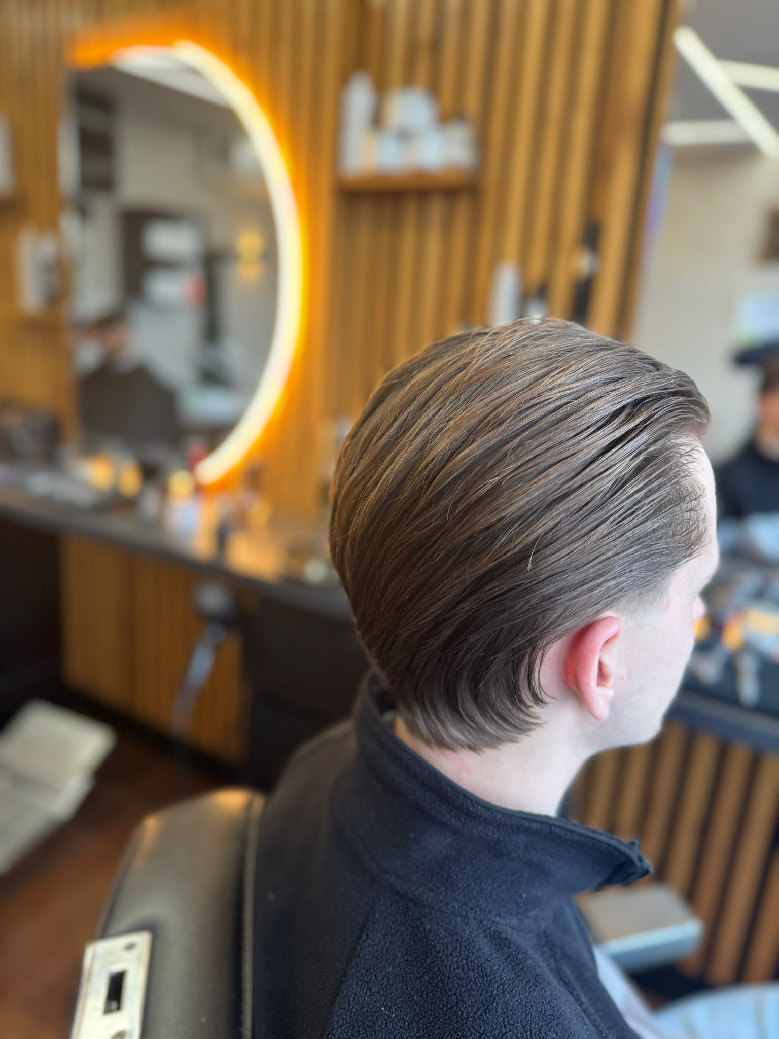 Barber refining a hairline with a straight razor